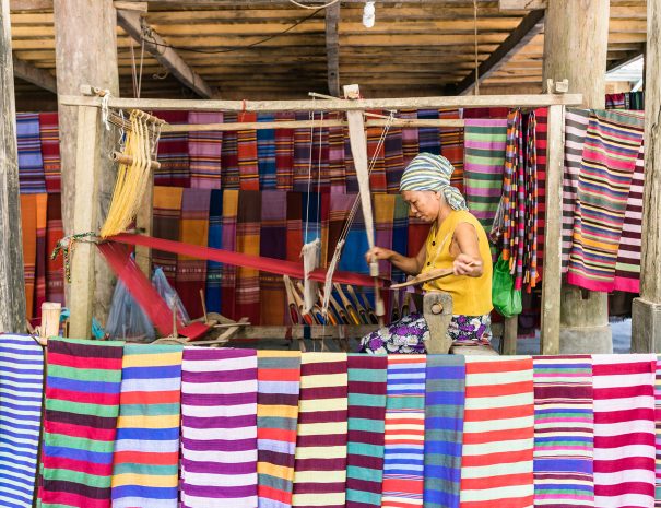 Lac Village, Mai Chau valley, Vietnam - October 18, 2016. Local woman diligently working at a loom, weaving colourful brocade fabric. Traditional patterns and colors.; Shutterstock ID 1176429079; purchase_order: -; job: -; client: -; other: -