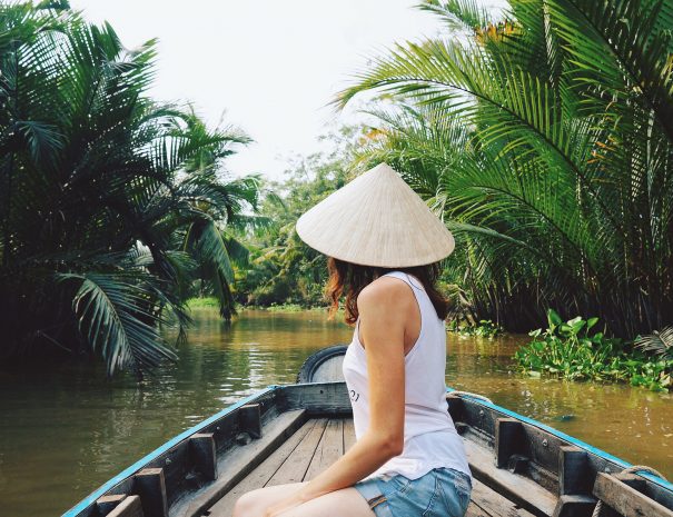 A young woman in a Vietnamese hat rides a boat on the Mekong River in Vietnam.The girl is traveling in a boat along the Mekong Delta in Vietnam.A serene river tour on the Mekong Delta, Can Tho Vietnam; Shutterstock ID 632121377; purchase_order: -; job: -; client: -; other: -