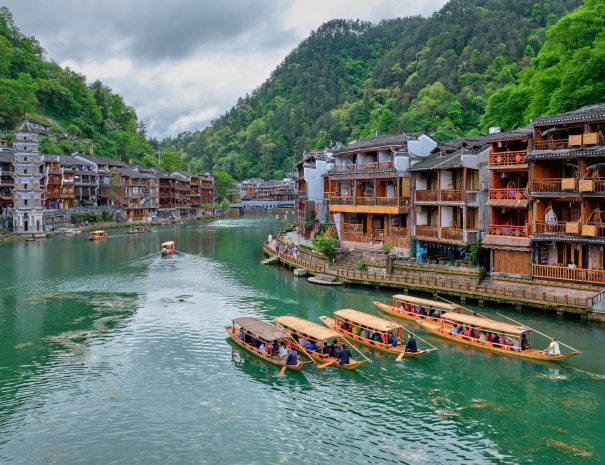 Chinese tourist attraction destination - Feng Huang Ancient Town (Phoenix Ancient Town) on Tuo Jiang River with Wanming Pagoda tower and tourist boat. Hunan Province, China; Shutterstock ID 1488909641; purchase_order: -; job: -; Name of competition (if applicable): -; other: -