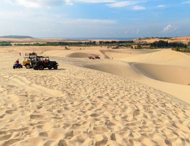 Mui Ne, Vietnam - May 20, 2018 : Landscape of white sand dune desert with off road car vehicle at Mui Ne, Vietnam, Popular tourist attraction; Shutterstock ID 1099594220; purchase_order: -; job: -; client: -; other: -