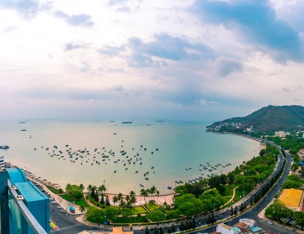 Panoramic coastal Vung Tau view from above, with waves, coastline, streets, coconut trees and Tao Phung mountain in Vietnam. Long exposure photography at sunset.; Shutterstock ID 1955579137; purchase_order: -; job: -; client: -; other: -
