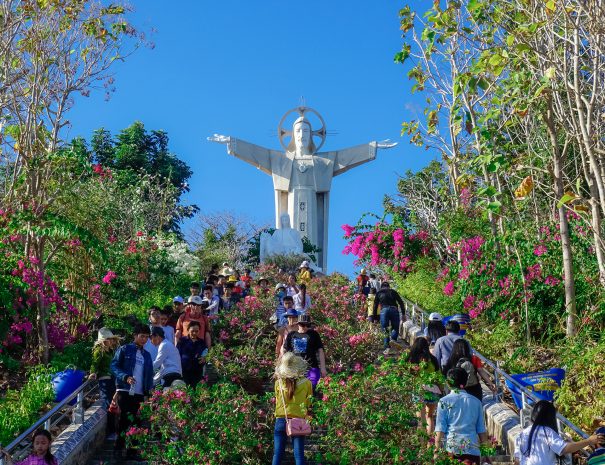 Vung Tau, Vietnam - February 21, 2018: Statue of Jesus Christ and many tourists walking in the park next to the statue.; Shutterstock ID 1516789739; purchase_order: -; job: -; client: -; other: -
